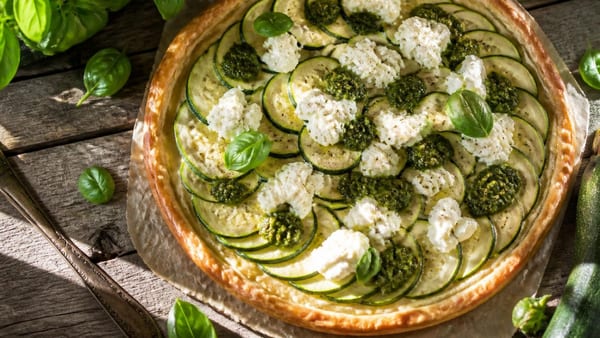 Descubre cómo preparar una tarta salada perfecta para el verano, combinando calabacín fresco, pesto aromático y burra…